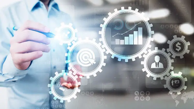 A businessperson points at interlocking gear icons representing procurement goals, growth charts, and automation