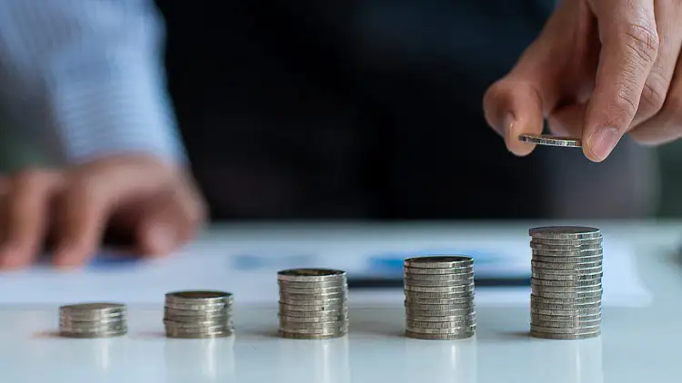Stacks of coins and receipts representing scattered tail spend adding up across an organization