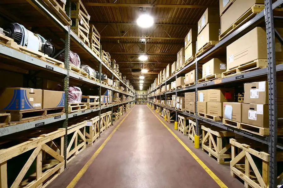 Warehouse aisle stocked with shelved boxes and raw material inventory